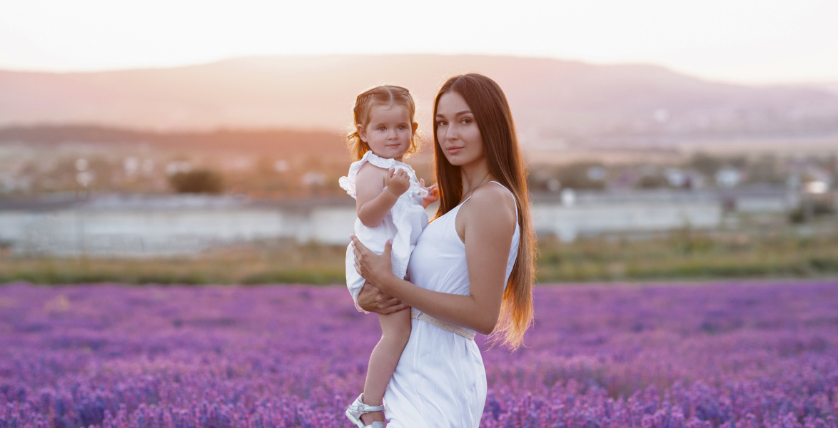 Beautiful young blonde woman holding baby-girl stand
